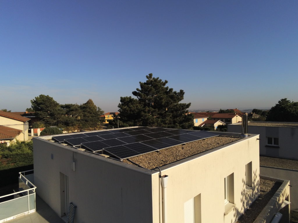 Installation photovoltaïque sur une maison à toit plat.

